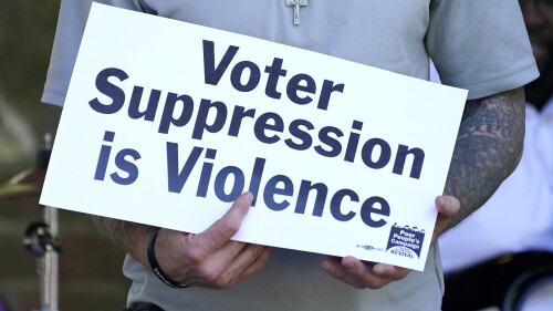 FILE - A person previously convicted of a felony felon holds a sign about voter suppression during a Poor People's Campaign assembly in Jackson, Miss., on Monday, April 19, 2021. The demonstrator was among speakers who called for Mississippi to simplify the way it restores voting rights to people convicted of some felonies. On Friday, June 30, 2023, the U.S. Supreme Court said it would not consider a case challenging Mississippi's practice of removing voting rights from people convicted of some crimes. (AP Photo/Rogelio V. Solis, File)