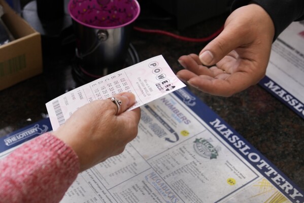 FILE - A customer purchases five Powerball tickets at a lottery agent, Tuesday, Oct. 10, 2023, in Haverhill, Mass. (AP Photo/Charles Krupa, File)