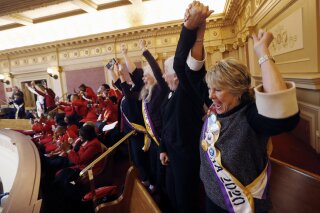 FILE - In this Monday, Jan. 27, 2020 file photo, Equal Rights Amendment supporter Donna Granski, right, from Midlothian Va., cheers the passage of the House ERA Resolution in the Senate chambers at the Capitol in Richmond, Va. A federal judge on Friday, March 5, 2021 dismissed a lawsuit filed by three Democratic state attorneys general that had sought to force the federal government to recognize Virginia's vote last year to ratify the Equal Rights Amendment and add it to the Constitution. (AP Photo/Steve Helber, File)