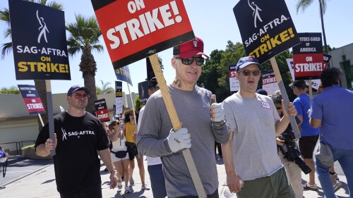 Actor Bob Odenkirk, center, carries a sign on a picket line outside Paramount studios on Wednesday, July 19, 2023, in Los Angeles. The actors strike comes more than two months after screenwriters began striking in their bid to get better pay and working conditions. (AP Photo/Chris Pizzello)