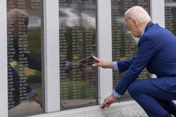 文件——2024年4月17日，宾夕法尼亚州斯克兰顿市，总统乔·拜登（Joe Biden）在斯克兰顿（Scranton）战争纪念碑的墙上触摸他的叔叔安布罗斯·芬尼根（Ambrose J.Finnegan，Jr.）的名字。他的叔叔死于二战。在美国被日本在夏威夷珍珠港发动的令人惊讶的致命炸弹袭击拖入第二次世界大战后，安布罗斯·芬尼根和他的三个兄弟，乔·拜登总统的叔叔约翰、爱德华和杰拉德，都是感受到参军和帮助保卫国家号召的数万名美国年轻人之一。（美联社照片/亚历克斯·布兰登档案）