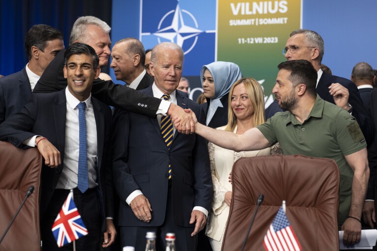 FILE - Ukrainian President Volodymyr Zelenskyy, right, reaches past U.S. President Joe Biden to shake hands with Lithuanian President Gitanas Nauseda as they stand with other NATO members, including British Prime Minister Rishi Sunak, left, during a meeting of the NATO-Ukraine Council in Vilnius, Lithuania, Wednesday, July 12, 2023. As chances rise of a Biden-Donald Trump rematch in the U.S. presidential election race, America鈥檚 allies are bracing for a bumpy ride, with concerns rising that the U.S. could grow less dependable regardless of who wins. (Doug Mills/Pool via 番茄直播, File)