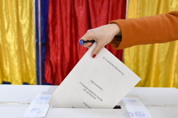 FILE - A woman casts her vote in Romania's legislative election, in Bucharest, Romania, Dec. 6, 2020. According to a study released Thursday, April 11, 2024, voters in 19 countries, including in three of the world’s largest democracies, are widely skeptical about whether their elections are free and fair, and many favor a strong, undemocratic leader. (Ǻ Photo/Andreea Alexandru, File)