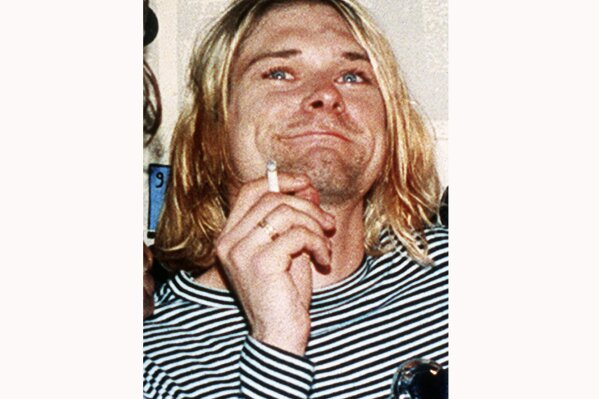 
              FILE - This 1993 file photo shows Kurt Cobain, the lead singer of the US rock band Nirvana. On Friday, April 5, 2019, people gathered throughout the day at Viretta Parkin in Seattle, leaving flowers, candles and written messages on the 25th anniversary of Cobain's death. Cobain, whose band Nirvana rose to global fame amid Seattle's grunge rock years of the early 1990s, shot himself on April 5, 1994 in his home near Lake Washington. (AP Photo/Mark J.Terrill, File)
            