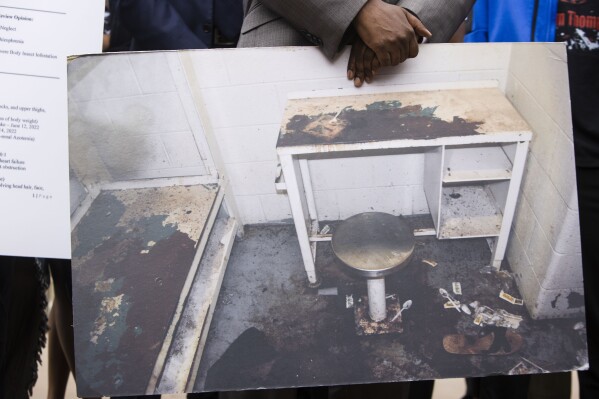 FILE - Attorney Michael Harper holds a photo of Lashawn Thompson's cell in the Fulton County, Ga., Jail at a news conference addressing the results of an independent autopsy determining the cause of death of Thompson, May 22, 2023, at the state Capital in Atlanta. Georgia’s Fulton County has reached a settlement with the family of Thompson, the man who died in a bedbug-infested cell in the county jail’s psychiatric wing, the family’s lawyers said Thursday, Aug. 3. (Christina Matacotta/Atlanta Journal-Constitution via AP, File)