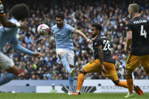 Manchester City's Ilkay Gundogan kicks the ball in an attempt to score, challenged by Leeds United's Weston McKennie during the English Premier League soccer match between Manchester City and Leeds United at Etihad stadium in Manchester, England, Saturday, May 6, 2023. (AP Photo/Rui Vieira)