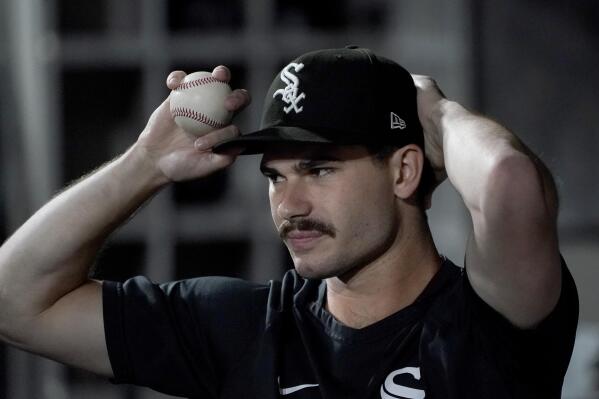 FILE - Chicago White Sox starting pitcher Dylan Cease adjusts his cap in the dugout during a baseball game against the Cleveland Guardians Wednesday, Sept. 21, 2022, in Chicago. White Sox Dylan Cease right-hander will receive the largest amount in the new $50 million pool for pre-arbitration players, earning $2,457,426. (AP Photo/Charles Rex Arbogast, File)