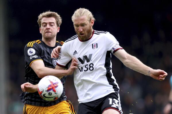 Leeds United's Patrick Bamford, left, and Fulham's Tim Ream battle for the ball during the English Premier League soccer match between Fulham and Leeds United at Craven Cottage, London, Saturday April 22, 2023. (Steven Paston/PA via AP)