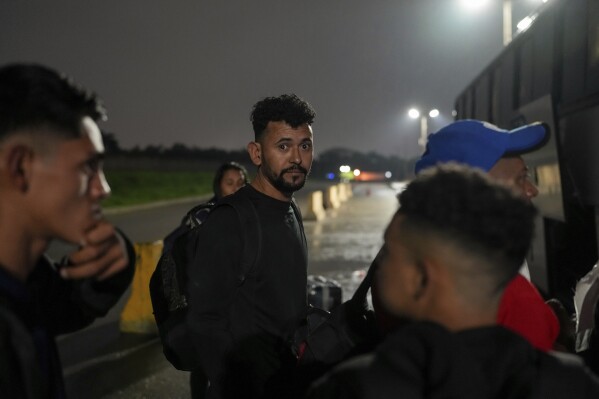 Diego, a Honduran migrant, gets on a bus in the hope of reaching the U.S., after being deported from that country, in San Pedro Sula, Honduras, Tuesday, Dec. 3, 2024. (AP Photo/Moises Castillo)
