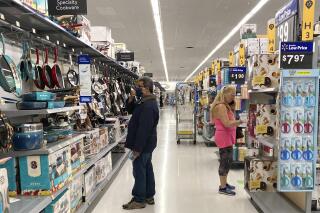 Consumers shop as they wear a mask at a Walmart store in Vernon Hills, Ill., Sunday, May 23, 2021. U.S. consumer confidence rose for a fifth month in June to the highest level since the pandemic began last year as households responded to increased vaccinations and the further re-opening of businesses. (AP Photo/Nam Y. Huh)