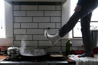 FILE - Jorge Sanhueza-Lyon stands on his kitchen counter to warm his feet over his gas stove during a snow storm on Feb. 16, 2021, in Austin, Texas. Following comments made by a member of the Consumer Product Safety Commission on Jan. 9, 2023, misleading claims that the Biden administration is planning on banning gas stoves have spread widely across social media platforms. (AP Photo/Ashley Landis, File)