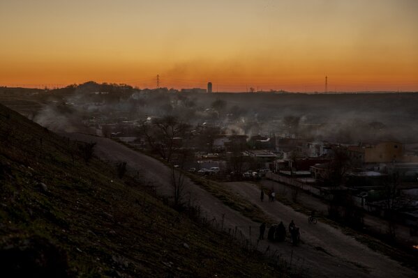 A general view during the sunset at the Canada Real shanty town, outside Madrid, Spain, Tuesday, Jan. 5, 2021. An illegal informal settlement that has spread over several decades as poor Spaniards, Roma people and Moroccan migrants sought a place to live, La Cañada's poor housing and make-shift shacks stretches some 14 kilometers (9 miles) along what was once a drover's pathway on the Spanish capital's southeastern industrial outskirts. Nowadays, it's home to some 7,500 people of low or no income. (AP Photo/Manu Fernandez)