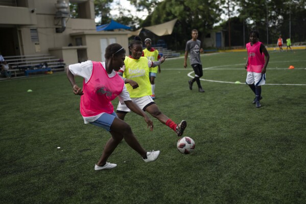 Teenage girls play soccer at the Union School in Port-au-Prince, Haiti, Monday, June 5, 2023. The school's soccer program aims to keep kids off the street and prevent them from joining gangs, as well as potentially recruit the next big stars. (AP Photo/Ariana Cubillos)