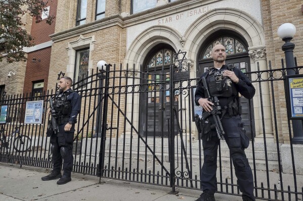 FILE - Hoboken Police officers stand watch outside the United Synagogue of Hoboken, Nov. 3, 2022, in Hoboken, N.J. A new guide from the Department of Homeland Security aims to help churches, synagogues, mosques and other houses of worship protect themselves at a time of heightened tensions in faith-based communities across the country. (AP Photo/Ryan Kryska, File)