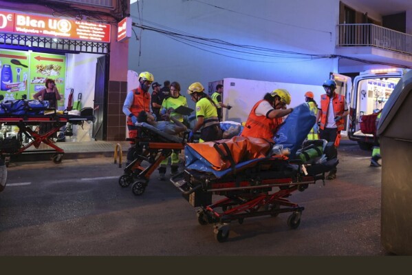 Medics take injured people away from a building that collapsed in Palma de Mallorca, Spain, Thursday May 23, 2024. Spanish emergency authorities say that four people have died and 21 more have been injured when a building collapsed on the island of Mallorca. (Isaac Buj/Europa Press via AP)