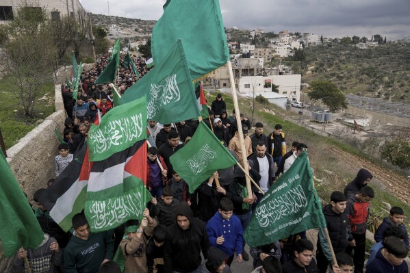 Palestinian demonstrators wave Hamas and their national flags during a protest against the killing of top Hamas official Saleh Arouri in Beirut, in the West Bank town of Arura, on Friday, Jan. 5, 2024. Arouri, the No. 2 figure in Hamas, was killed in an explosion blamed on Israel. He is the highest-ranked Hamas figure to be killed in the nearly three-month war between Israel and Hamas. (AP Photo/Majdi Mohammed)