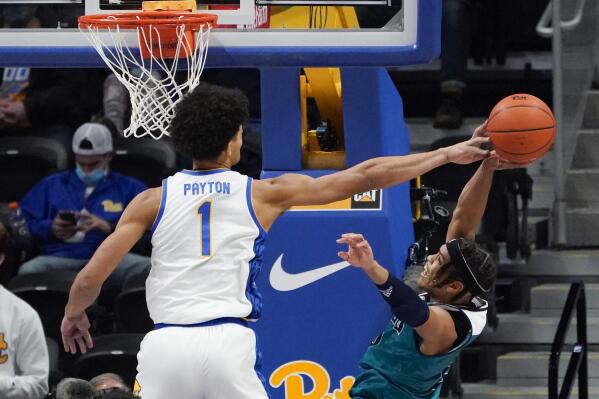 Pittsburgh's Chris Payton (1) blocks a shot by UNC Wilmington's Shykeim Phillips during the second half of an NCAA college basketball game Tuesday, Nov. 16, 2021, in Pittsburgh. Pittsburgh won 59-51. (AP Photo/Keith Srakocic)