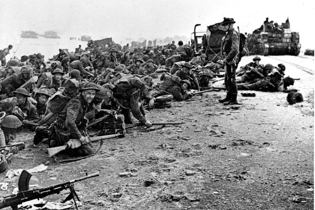 After landing at the shore, these British troops wait for the signal to move forward, during the initial Allied landing operations in Normandy, France, June 6, 1944. (AP Photo)