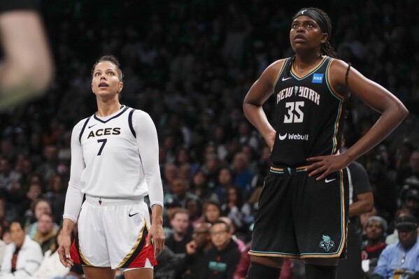 FILE - Las Vegas Aces' Alysha Clark (7) and New York Liberty's Jonquel Jones (35) watch a free throw attempt during the second half in Game 3 of a WNBA basketball final playoff series, Sunday, Oct. 15, 2023, in New York. WNBA players have one less option to play overseas with the conflict in Israel, adding to diminishing opportunities amid the ongoing war between Russia and Ukraine. But China has returned as a top landing spot with stars Alyssa Thomas and Jonquel Jones both planning on going to the Asian nation. (AP Photo/Frank Franklin II, File)