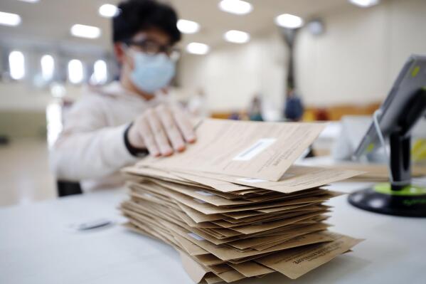 Allen Ni opens mailed-in ballots at Crossway Village in Lee, Mass. on Tuesday, Nov. 8, 2022. (Stephanie Zollshan/The Berkshire Eagle via AP)