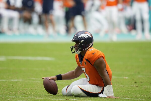 Denver Broncos quarterback Russell Wilson (3) sits on the field after he was sacked during the second half of an NFL football game against the Miami Dolphins, Sunday, Sept. 24, 2023, in Miami Gardens, Fla. The Dolphins defeated the Broncos 70-20. (AP Photo/Rebecca Blackwell)