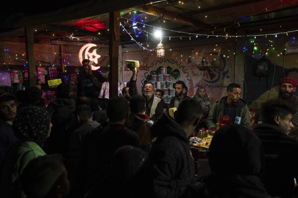 Palestinians buy food for a pre-dawn meal before fasting during the Muslim holy month of Ramadan in Rafah, Gaza Strip, Sunday, March 10, 2024. (AP Photo/Fatima Shbair)