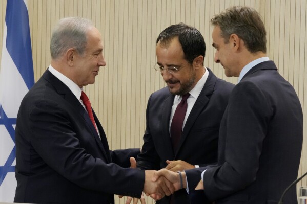 Cypriot President Nikos Christodoulides, center, Greek Prime Minister Kyriakos Mitsotakis, right, and Israeli Prime Minister Benjamin Netanyahu shake hands after a press conference at the presidential palace in Nicosia, Cyprus, on Monday, Sept. 4, 2023. Israel's prime minister is floating the idea of building infrastructure projects such as a fiber optic cable linking countries in Asia and the Arabian Peninsula with Europe through Israel and Cyprus. (AP Photo/Petros Karadjias, Pool)
