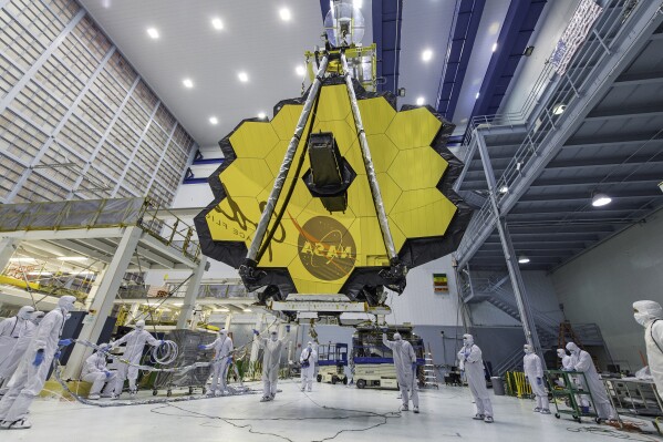 FILE - In this photo provided by NASA, technicians lift the mirror of the James Webb Space Telescope using a crane, April 13, 2017, at the Goddard Space Flight Center in Greenbelt, Md. Astronomers have discovered the most distant black hole yet using the Webb Space Telescope, but that record isn't expected to last. Webb already has spotted other black holes that appear to be even more distant, but those findings are still under review. (Laura Betz/NASA via AP, File)