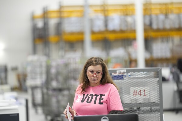 A worker inspects ballots at a ballot processing center Tuesday, March 5, 2024, in the City of Industry, Calif. (AP Photo/Marcio Jose Sanchez)