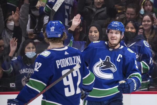 Vancouver Canucks' Bo Horvat, right, and Vasily Podkolzin celebrate Horvat's goal against the New Jersey Devils during the second period of an NHL hockey game Tuesday, March 15, 2022, in Vancouver, British Columbia. (Darryl Dyck/The Canadian Press via AP)