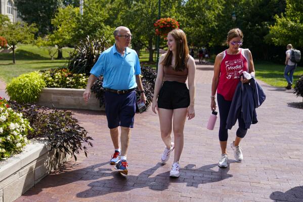 Emily Korenman, freshman, 18, center, from Dallas, walks with her parents Wendy and Phillip through campus at Indiana University in Bloomington, Ind., Tuesday, Aug. 16, 2022. Korenman, who decided to study business at Indiana University, said she was frustrated to learn her new state passed new abortion restrictions that take effect Sept. 15 and allow limited exceptions. The 18-year-old said it didn't change her mind about attending a school she really likes, but she isn’t sure what she would do if she became pregnant during college. (AP Photo/Michael Conroy)