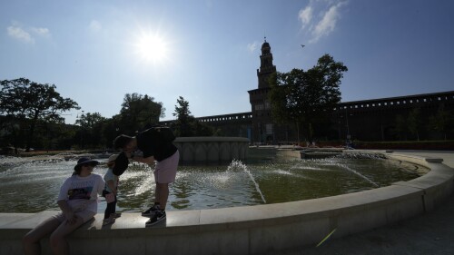 Tourists cool off in a public fountain at the Sforzesco Castle, in Milan, Italy, Saturday, July 15, 2023. Temperatures reached up to 42 degrees Celsius in some parts of the country, amid a heat wave that continues to grip southern Europe. (AP Photo/Luca Bruno)