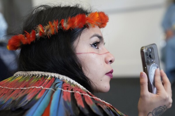 Txai Surui films a question from a journalist for Indigenous Peoples Minister Sonia Guajajara during the Skoll World Forum in Oxford, England, April 10, 2024. (AP Photo)