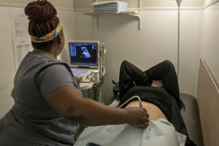 FILE - An operating room technician performs an ultrasound on a patient at Hope Medical Group for Women in Shreveport, La., on July 6, 2022. Doctors in states with strict abortion restrictions say an increasing number of pregnant women are seeking early prenatal testing, hoping to detect serious problems while they still have time to choose whether to continue the pregnancy. (AP Photo/Ted Jackson, File)