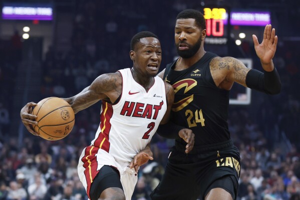 Miami Heat guard Terry Rozier (2) drives against Cleveland Cavaliers forward Marcus Morris Sr. (24) during the first half of an NBA basketball game, Wednesday, March 20, 2024, in Cleveland. (AP Photo/Ron Schwane)