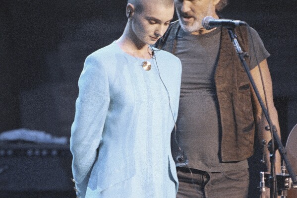 FILE - Kris Kristofferson comforts Sinead O'Connor after she was booed off stage during the Bob Dylan anniversary concert at New York Madison Square Garden, on Oct. 17, 1992. The performance was O'Connor's first live event since she ripped a picture of Pope John Paul II during a performance on 