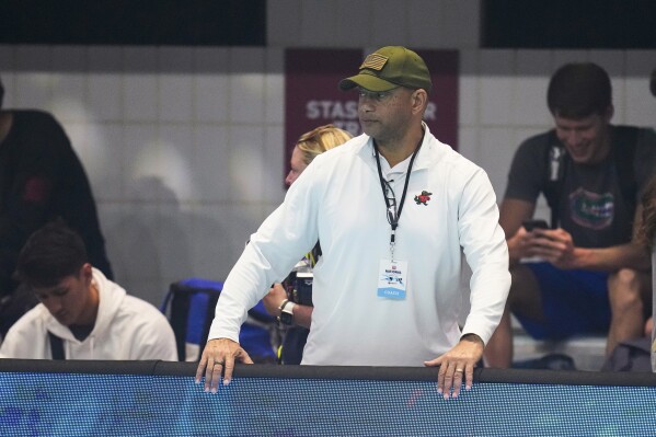FILE - Coach Anthony Nesty watches as swimmers warm up at the U.S. nationals swimming meet in Indianapolis, June 27, 2023. Nesty made more history Thursday, Sept. 21, when he was picked to lead the U.S. men's swimming team in Paris, where he will become the first Black head coach for the powerhouse American squad at the Olympics. Nesty's selection was announced by USA Swimming, which also appointed Todd DeSorbo to head the women's squad next summer. (AP Photo/Michael Conroy, File)