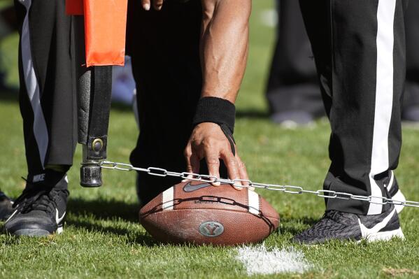 FILE - Officials measure for a first down during an NCAA college football game between USC and BYU, Saturday, Sept. 14, 2019, in Provo, Utah. College football administrators are looking at ways to reduce the number of plays in games in the name of player safety, with a tweak in clock operating procedures likely the first step. A proposal to let the game clock continue running when a team makes a first down, except in the last two minutes of a half, has broad support. (AP Photo/George Frey, File)