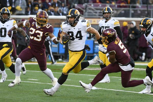 Iowa tight end Sam LaPorta (84) takes a short pass upfield past Minnesota defensive backs Jordan Howden (23) and Justin Walley (5) during the first half an NCAA college football game on Saturday, Nov. 19, 2022, in Minneapolis. (AP Photo/Craig Lassig)