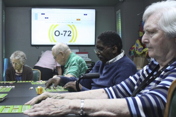 Eberline Nugent, left, Johnny Griffin, Jay Cossey and Carrie Dickson play bingo during activity time at The Retreat at Kenwood assisted living facility in Texarkana, Texas on Friday, May 17, 2024. Cossey recalls, “My brother came and said he wanted to take me home. ... I told him I am home. I’m home because I feel good here.” (AP Photo/Mallory Wyatt)