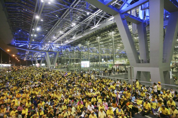 FILE - Anti government protesters sits in front of the departure terminal at Suvarnabhumi airport, Bangkok in the early hours of Wednesday Nov. 26, 2008. A Thai court on Friday, March 29, 2024, acquitted nearly 70 people of all charges related to mass protests that shut down Bangkok’s two airports in 2008. Members of the same group, opposed to a government headed that year by political allies of ousted former Prime Minister Thaksin Shinawatra, also briefly seized a state television station and occupied the Government House for three months. (AP Photo/Sakchai Lalit, File)