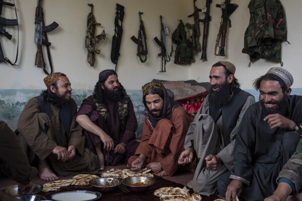 Taliban fighters enjoy lunch inside an adobe house that is used as a makeshift checkpoint in Wardak province, Afghanistan, Thursday June 22, 2023. (AP Photo/Rodrigo Abd)