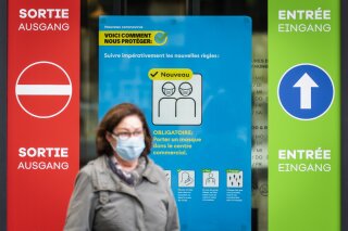 A woman wearing a protective mask walks in front of a FOPH poster in front of a shopping centre in Fribourg, Switzerland, Friday, Oct. 16, 2020. Europe is at a “turning point” in the fight against the coronavirus, said Bertrand Levrat, head of Switzerland’s biggest hospital complex, acknowledging growing public fatigue over anti-COVID measures but says people must buckle down as Switzerland grapples with record daily case counts with measures like limiting the size of gatherings and stripping soldiers of weekend leave.
(Jean-Christophe Bott/Keystone via AP)