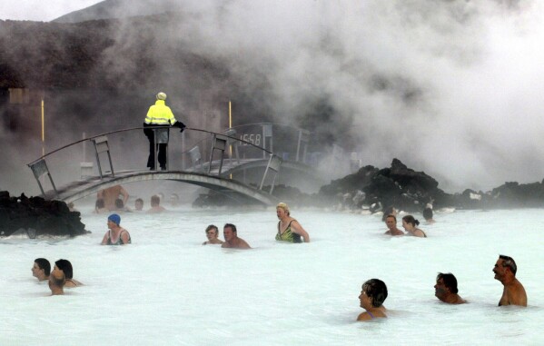 FILE-Bathers enjoy the warm water of the Blue Lagoon on Iceland on Sept.5, 2003. The geothermal spa Blue Lagoon has temporarily closed after a series of earthquakes have put Iceland's southwestern corner on volcanic alert, reaching a state of panic on Thursday when a magnitude 5.0 earthquake occurred just after midnight. (AP Photo/Frank Augstein, File)