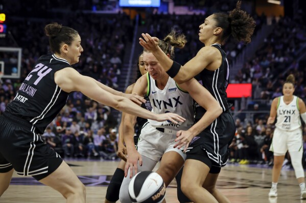 Minnesota Lynx's Alanna Smith, center, is defended by Golden State Valkyries' Cecilia Zandalasini (24) and Stephanie Talbot, right, in the first half of a WNBA basketball game in San Francisco, Sunday, June 1, 2025. (Carlos Avila Gonzalez/San Francisco Chronicle via AP)
