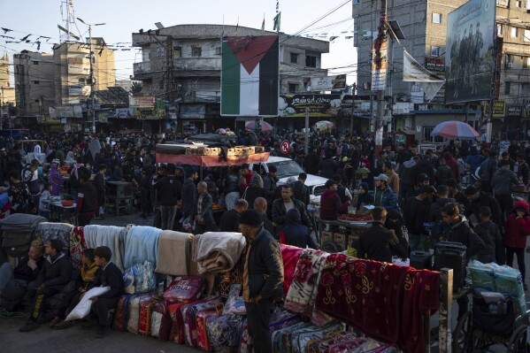Palestinians buy goods at a street market in Rafah, Gaza Strip, Tuesday, Feb. 20, 2024. An estimated 1.5 million Palestinians displaced by the war took refuge in Rafahor, which is likely Israel's next focus in its war against Hamas.(AP Photo/Fatima Shbair)