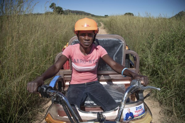 Anna Bhobho delivers tomatoes to a market place on her electric tricycle in Hwedza, Zimbabwe, Thursday, March 6 2025. (AP Photo/Aaron Ufumeli)