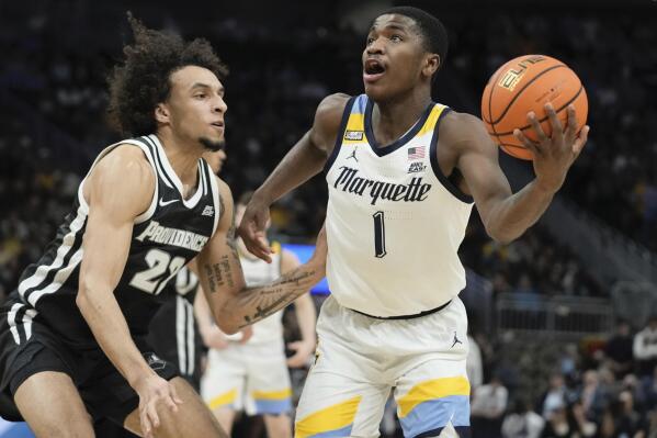 Marquette's Kam Jones drives by Providence's Devin Carter during the first half of an NCAA college basketball game Wednesday, Jan. 18, 2023, in Milwaukee. (AP Photo/Morry Gash)