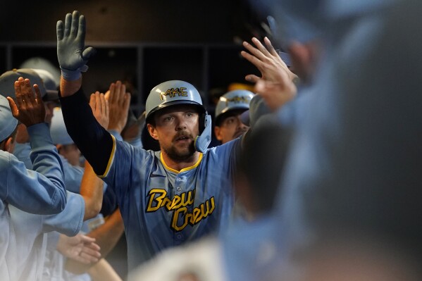 Milwaukee Brewers' Rhys Hoskins is congratulated in the dugout after hitting a grand slam during the first inning of a baseball game against the New York Mets, Friday, Sept. 27, 2024, in Milwaukee. (AP Photo/Aaron Gash)