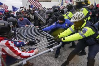 FILE - In this Jan. 6, 2021, file photo violent insurrectionists loyal to President Donald Trump supporters try to break through a police barrier at the Capitol in Washington. A month ago, the U.S. Capitol was besieged by Trump supporters angry about the former president's loss. While lawmakers inside voted to affirm President Joe Biden's win, they marched to the building and broke inside. (AP Photo/John Minchillo, File)
